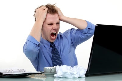 Frustrated man looking at laptop