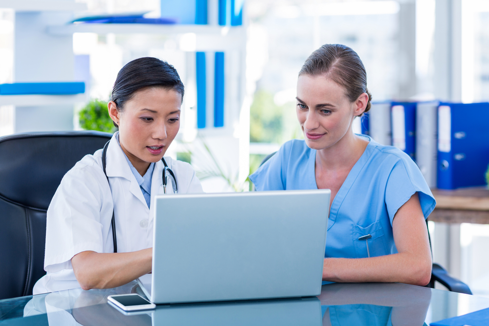 Doctor and nurse looking at laptop in medical office